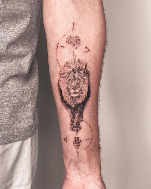 tatuagem-de-leao-6 Braço com tatuagem de leão ao centro, cercado por desenhos de cérebro e coração, com linhas e triângulos.