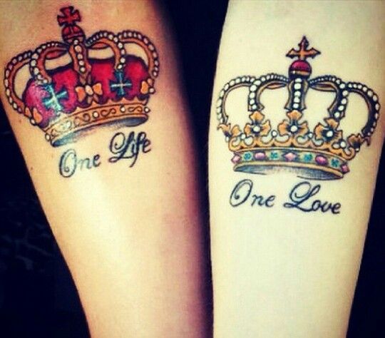 Duas tatuagens de coroas nos bra&ccedil;os, uma com a frase "One Life" e outra com "One Love".