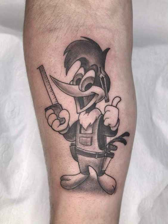 Desenho de personagem animado tatuado na pele, segurando uma serra e fazendo sinal de positivo com a m&atilde;o.