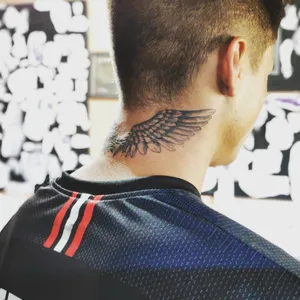 Man with wing tattoo on neck wearing sports jersey