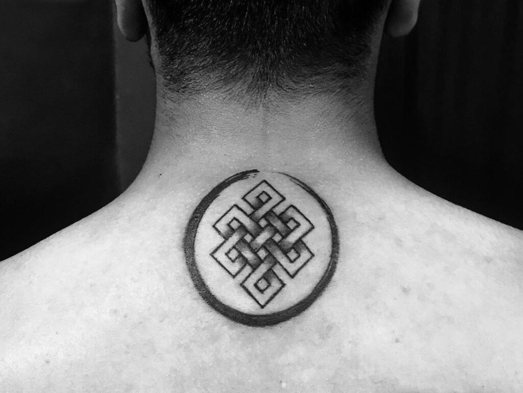 Um tatuagem preta de nó infinito dentro de um círculo nas costas de uma pessoa.