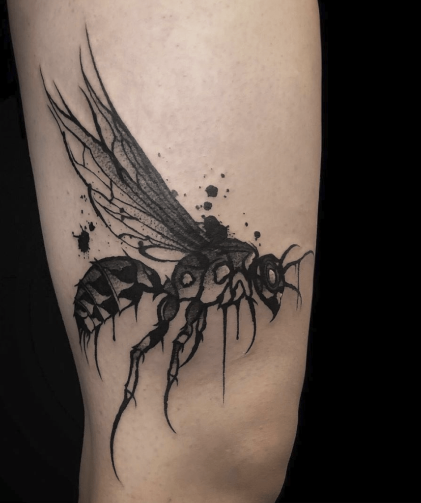 tatuagem-de-marimbondo-3-857x1024-1 Tatuagem de inseto estilizado com asas detalhadas e tinta preta, no braço de uma pessoa.