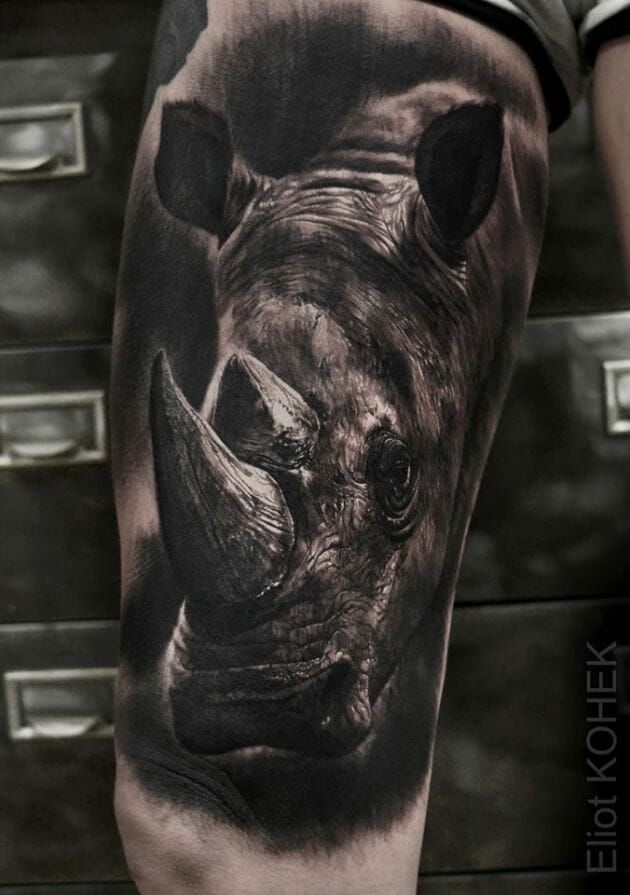 Tatuagem realista de rinoceronte em um bra&ccedil;o, destacando detalhes sombreados e texturas.