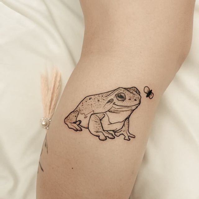 tatuagem-de-sapo-2 Tatuagem de sapo com uma abelha próxima, localizada no braço de uma pessoa.