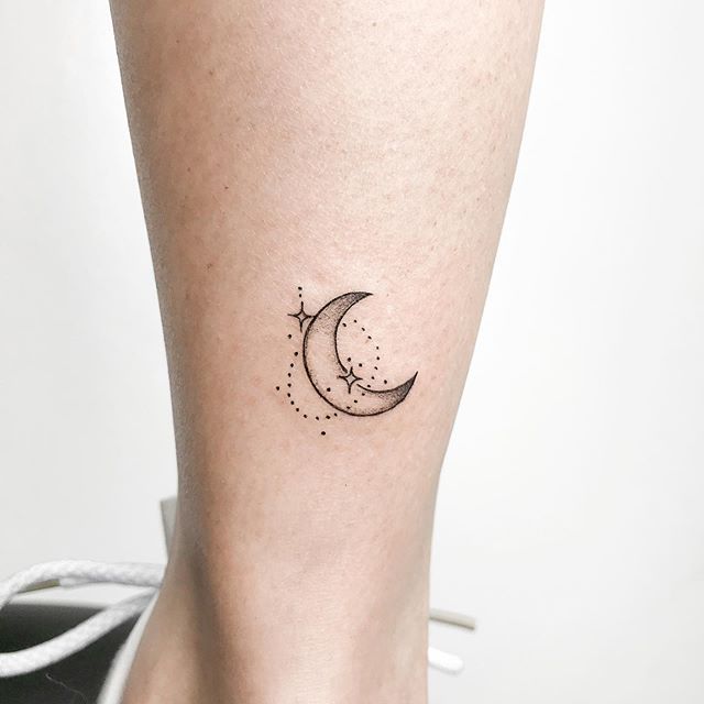 2405e4c777b3ad8ce788f32878d118bc Tatuagem de lua crescente e estrelas no tornozelo de uma pessoa, com design minimalista em linha fina.