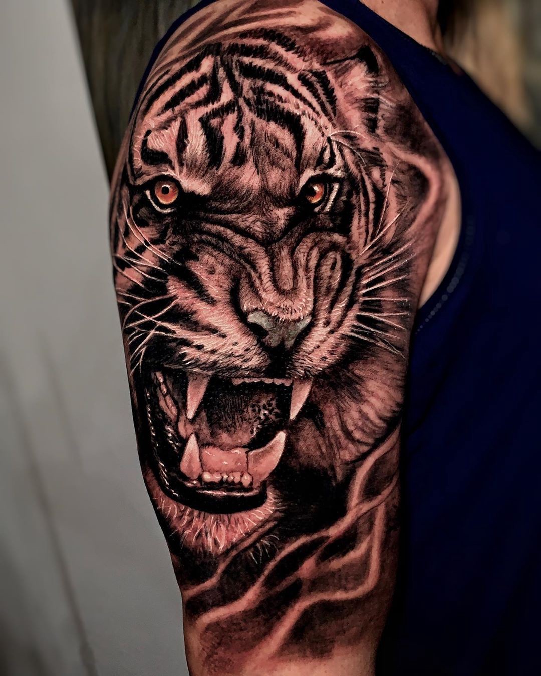 134dcj1mw9tl2zthgorlcra Tatuagem realista de tigre rugindo no braço de uma pessoa, destacando detalhes nos olhos e dentes.