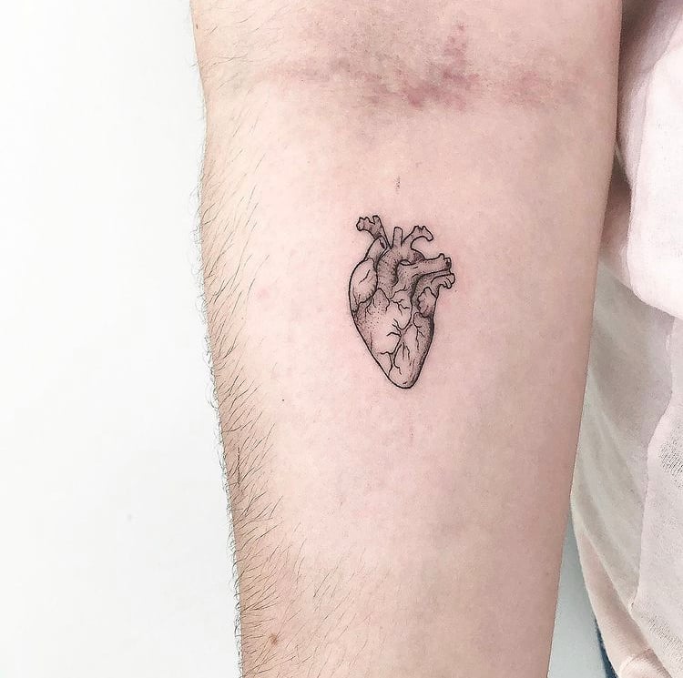 w9999-9 Braço com tatuagem de coração anatômico em linha fina e preta.