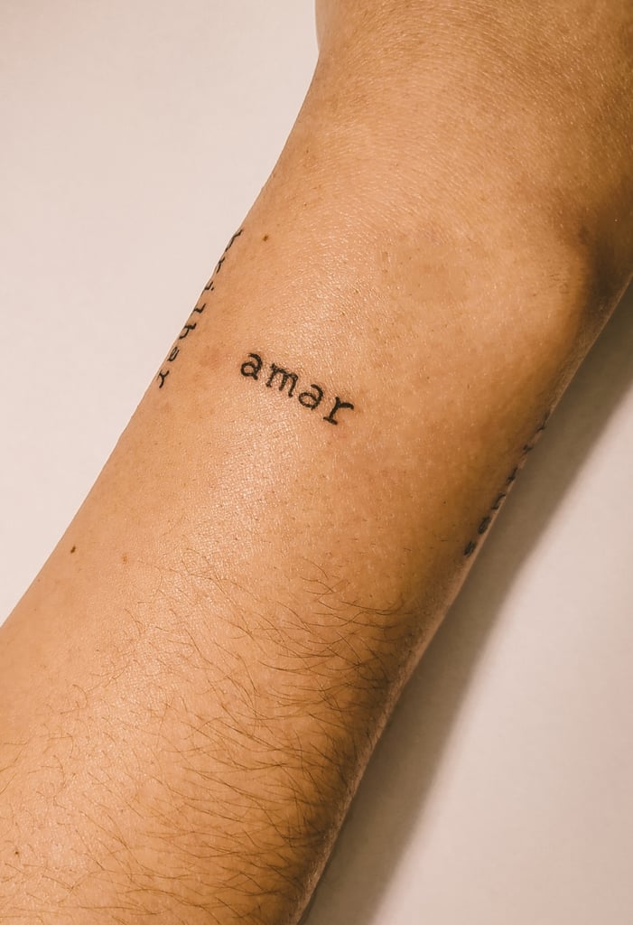 w701 Braço com tatuagem da palavra "amar" em fonte simples e preta.