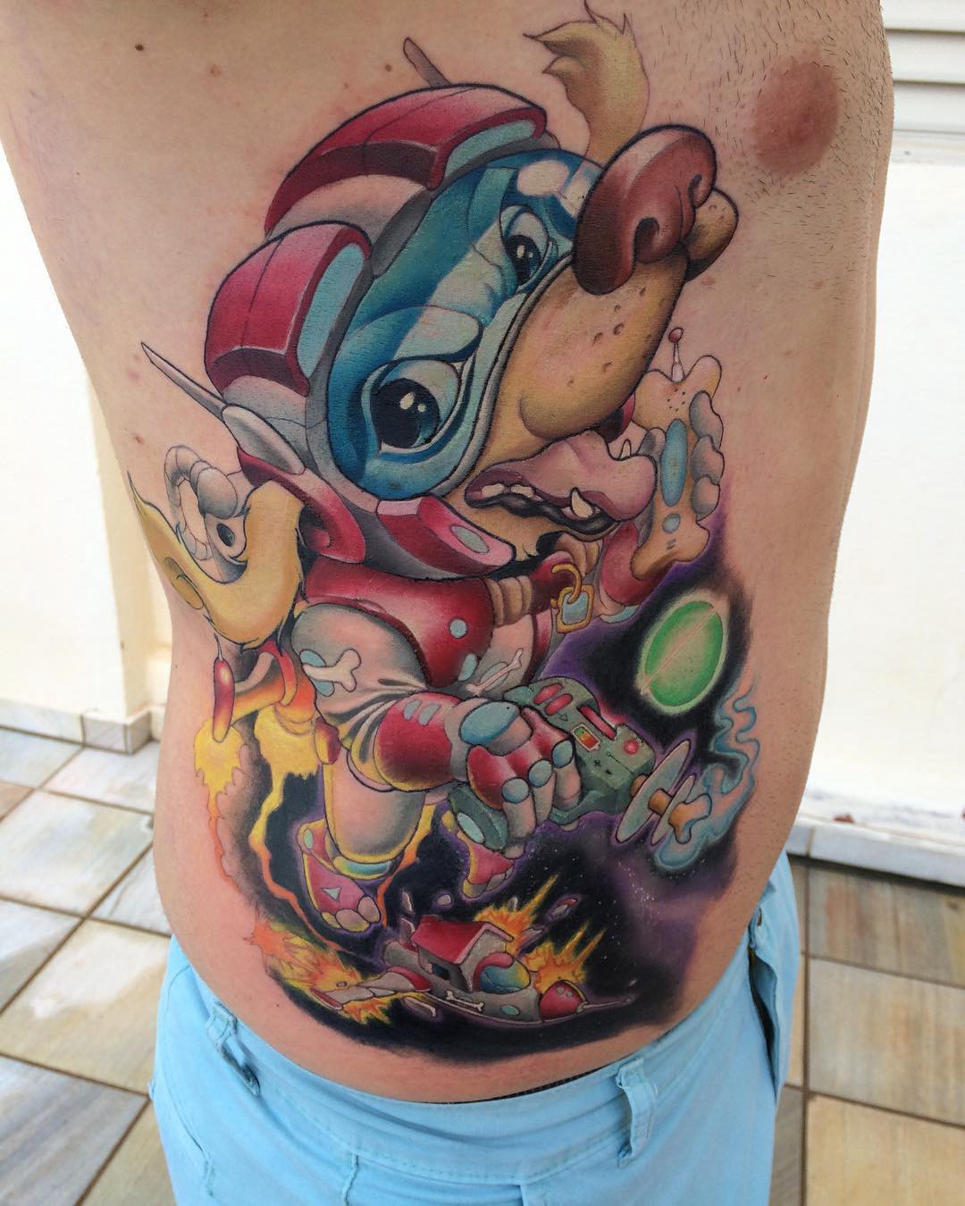 1wg5c7ta_k-ep5rucacq-vq-1 Tatuagem colorida de personagem canino em traje espacial, segurando arma de raios, com fundo de explosões e espaço.