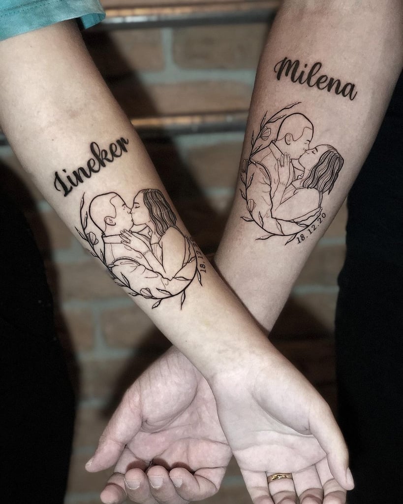 w819-181 Dois antebraços com tatuagens de um casal se beijando, acompanhadas de nomes e uma data.
