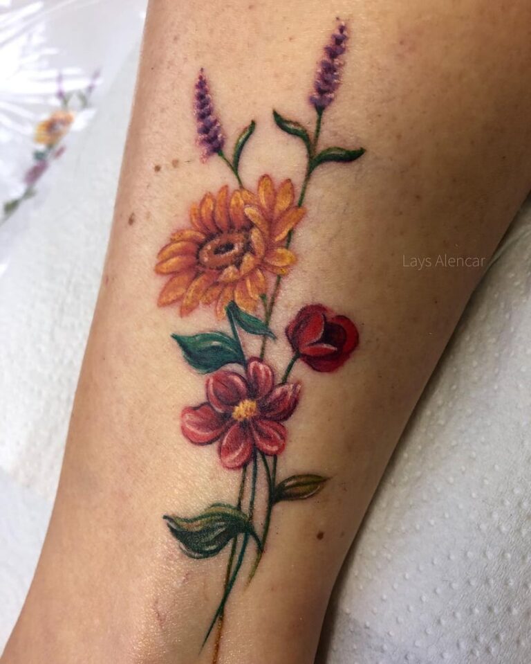 Tatuagem de flores coloridas no braço, incluindo girassol, papoula e lavanda. Arte vibrante mostrando beleza natural.