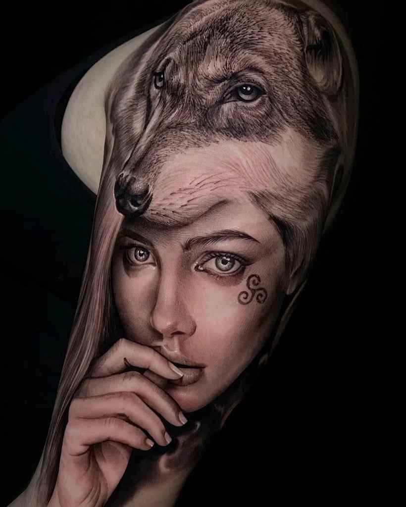 Tatuagem realista de lobo e mulher com detalhes faciais detalhados e símbolos.