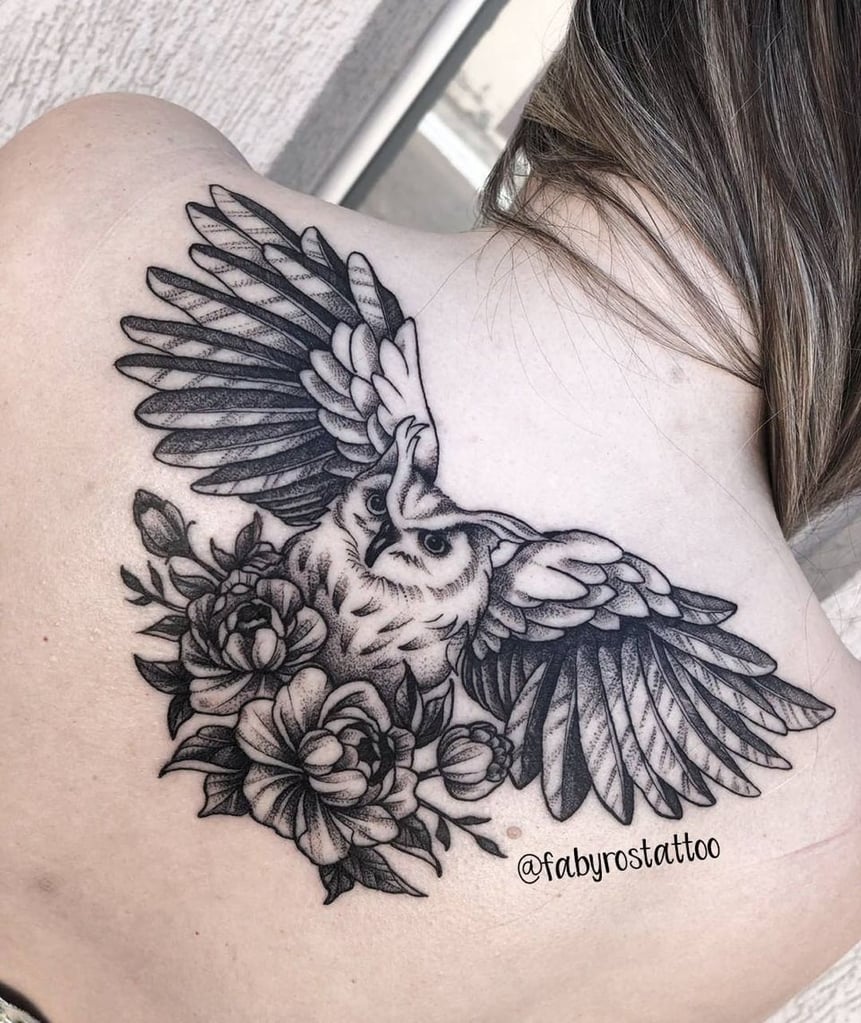 w861 Tatuagem de coruja voando com flores, localizada no ombro de uma pessoa.