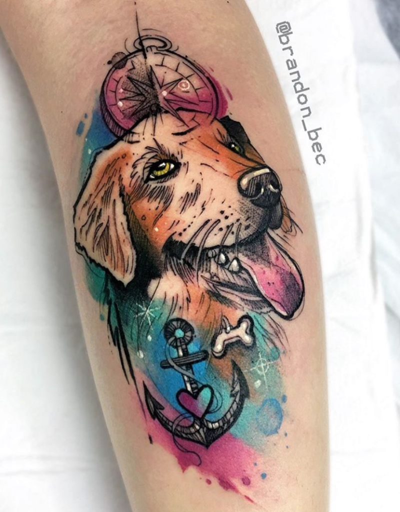Tatuagem colorida de cachorro com bússola e âncora no braço, carregada de elementos náuticos.