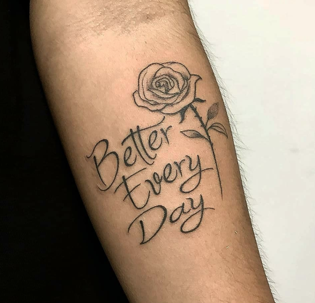 Tatuagem de rosa com a frase Better Every Day em um braço, simbolizando crescimento e melhoria contínua.