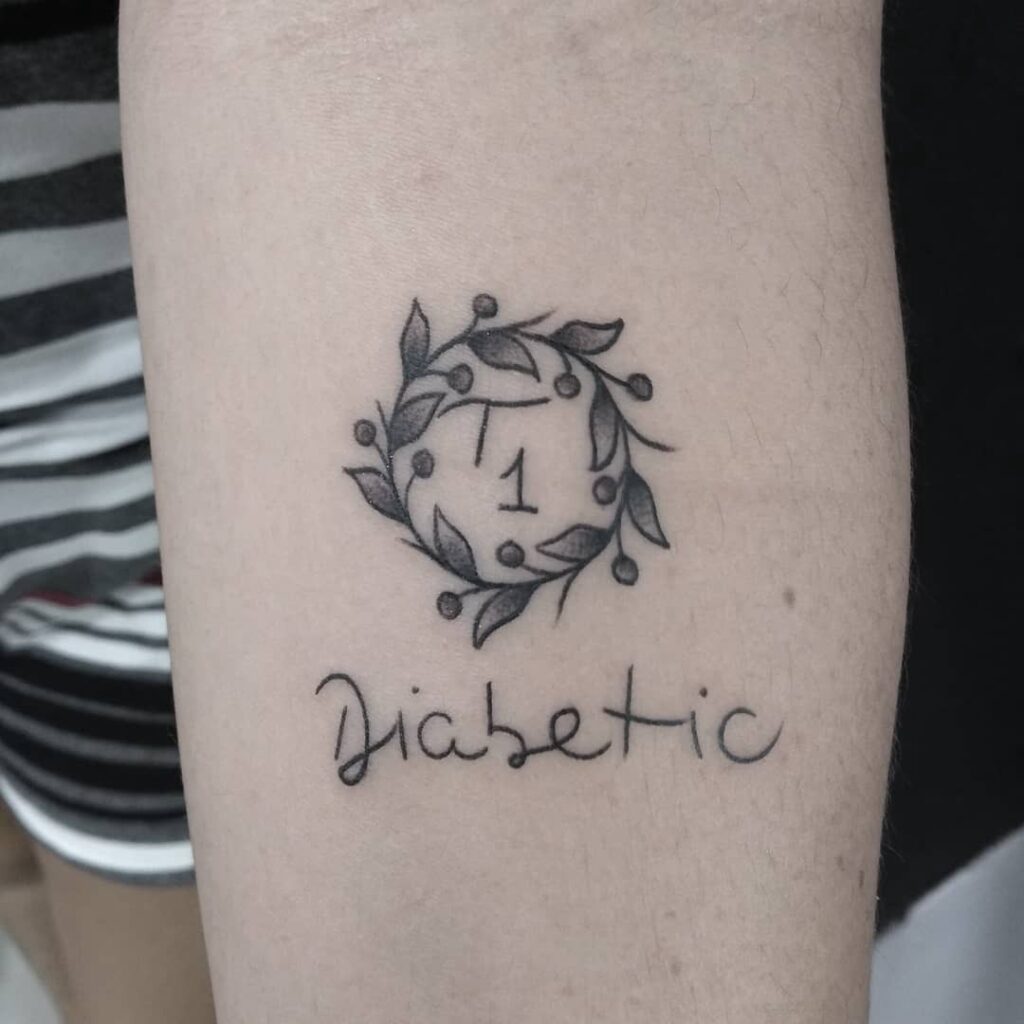 Tatuagem no braço com o número 1 cercado por folhas e a palavra Diabetic em estilo manuscrito.