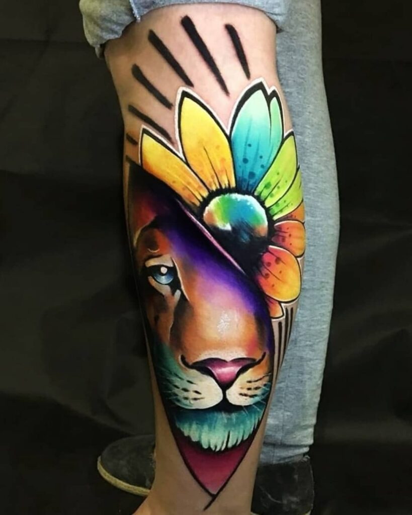 Tatuagem colorida de leão com flores em uma panturrilha, destacando-se pelo visual vibrante e artístico.