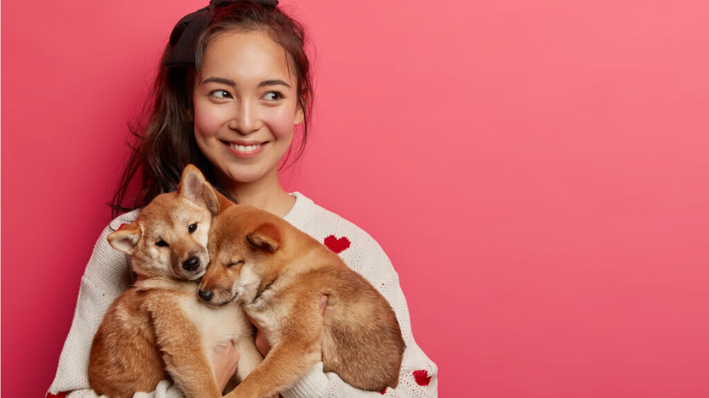 mulher abraçando com carinho dois cães