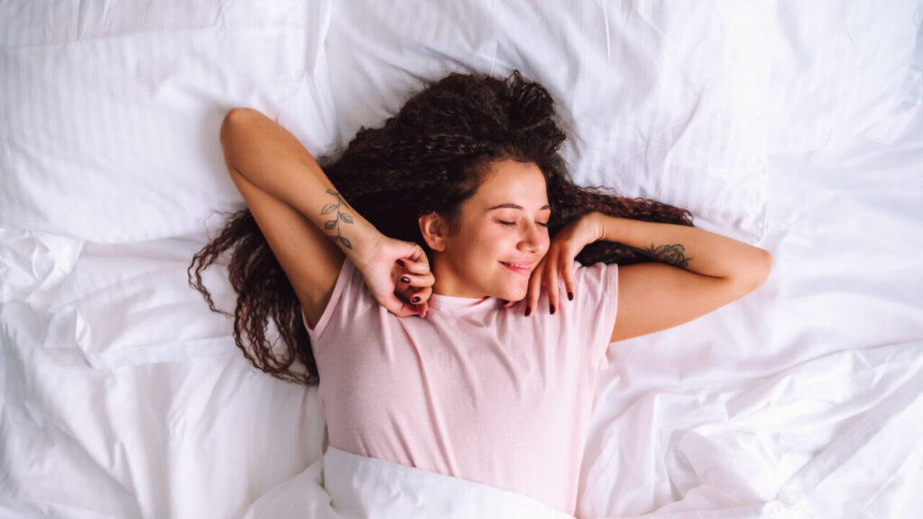 mulher se espreguiçando em uma cama