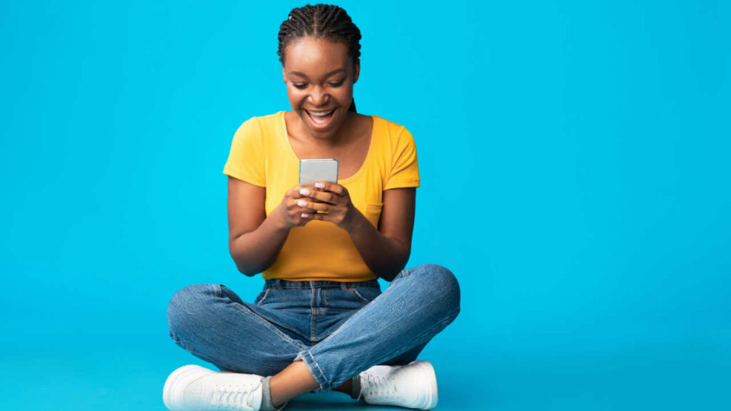 mulher negra sentada de pernas cruzadas em fundo azul
