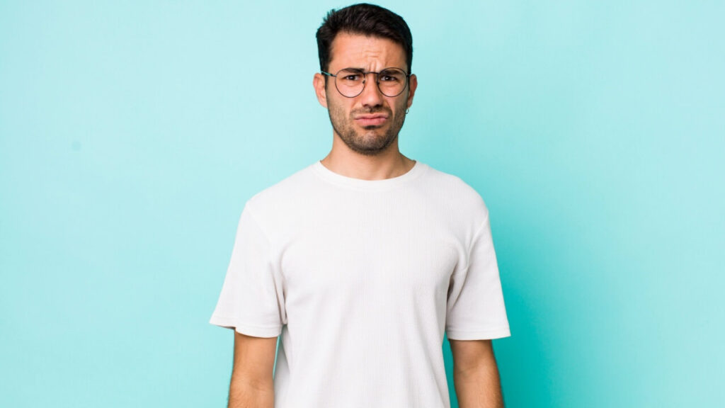 Homem sentindo-se triste, com um olhar infeliz, frustrado.