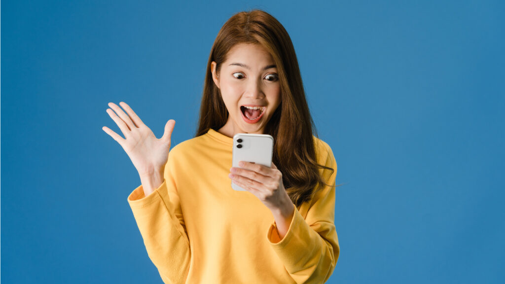 Mulher oriental com celular na mão