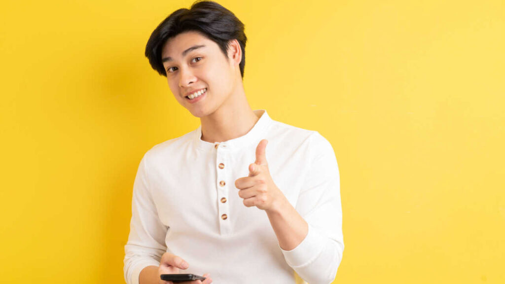 homem com traços asiaticos em fundo amarelo