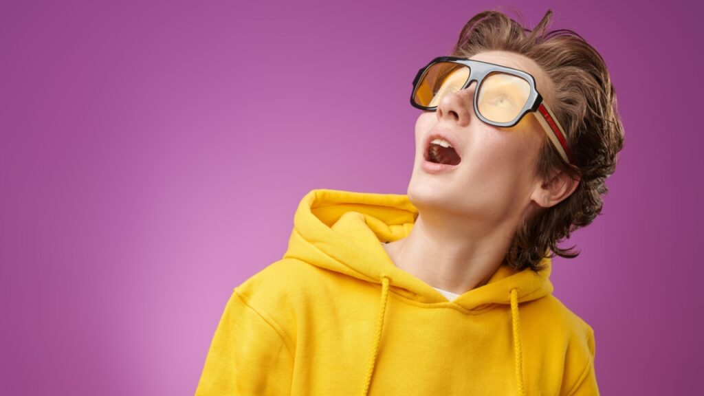 mulher usando óculos escuro e olhando para o alto de boca aberta em fundo roxo