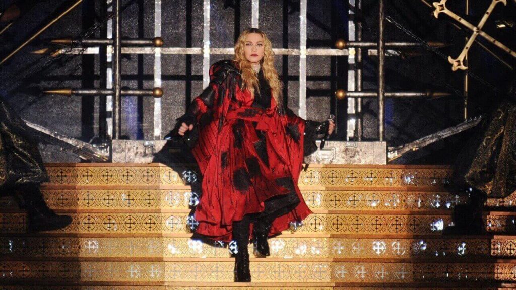 fotografia da cantora madonna em cima de um palco em formato de escada dourada