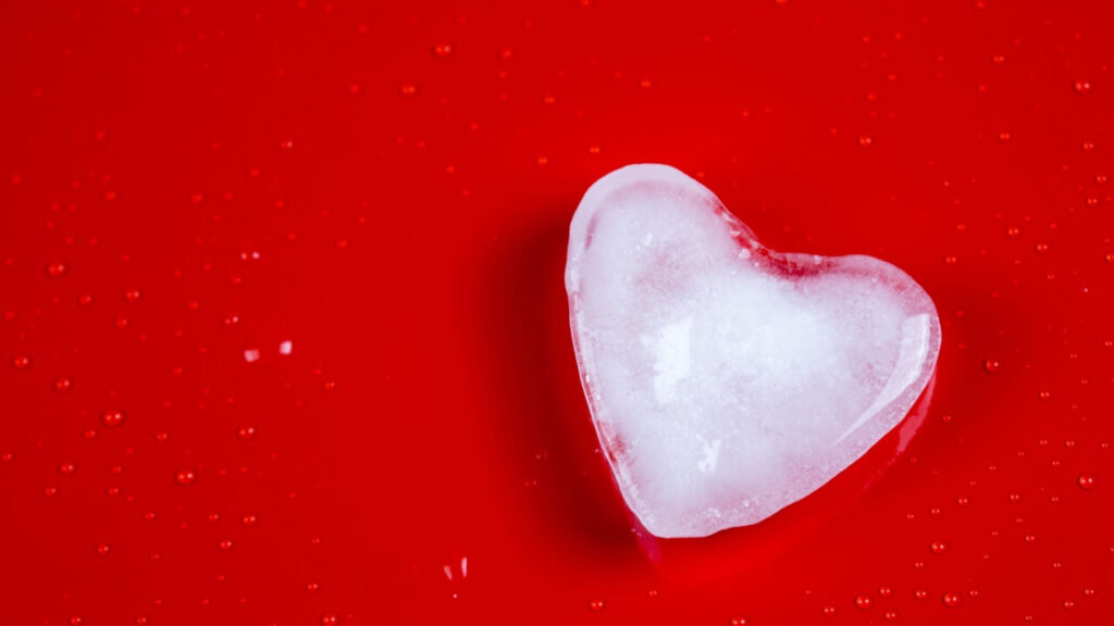 Coração de gelo e gotas em um fundo vermelho.