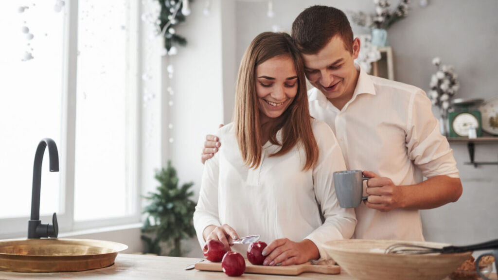 casal hétero vestindo roupa branca e cozinhando juntos