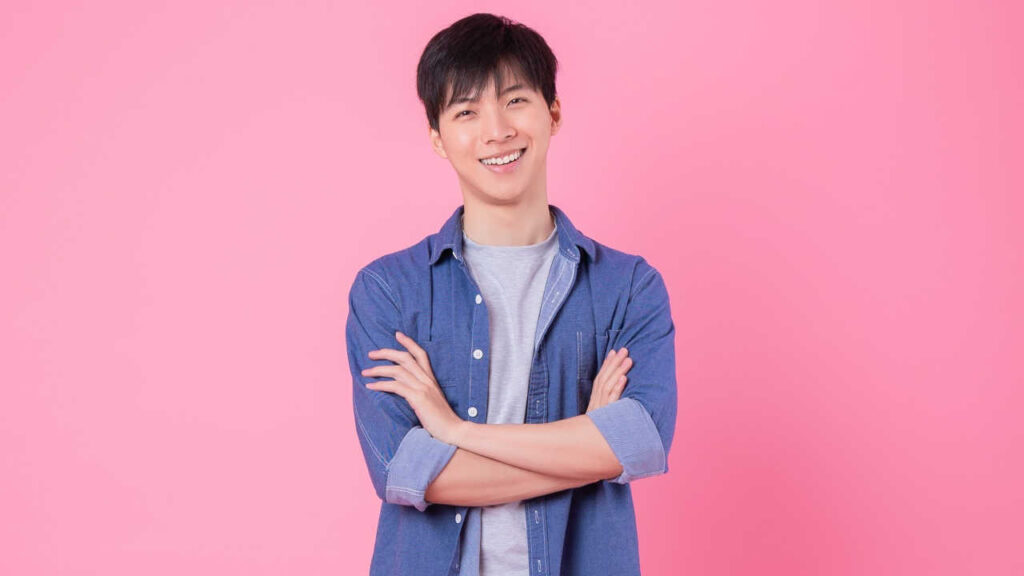 homem com traços asiáticos em fundo rosa