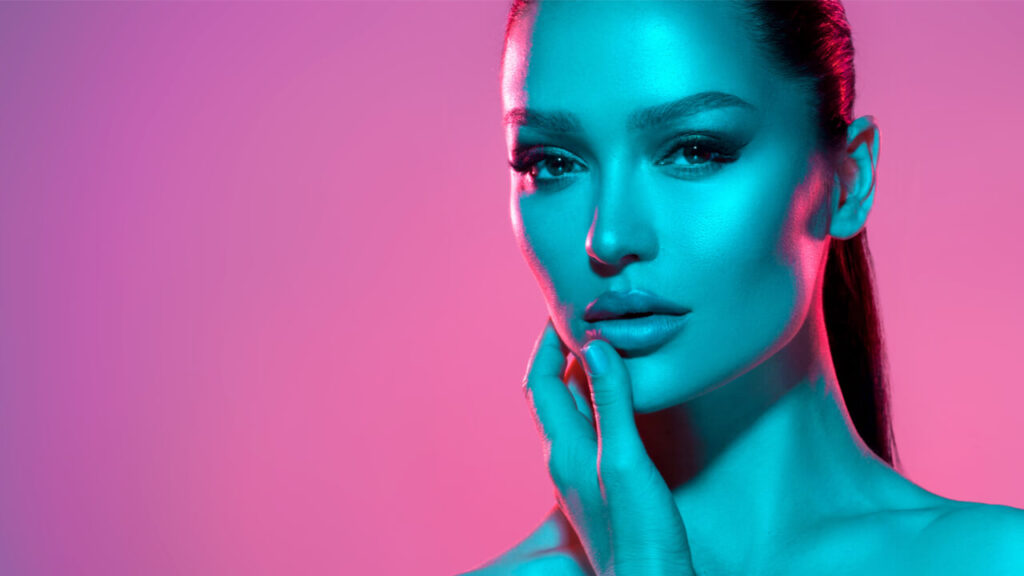 Mulher com rosto iluminado, posando no estúdio.