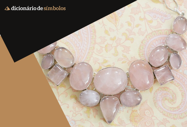 significado-do-quartzo-rosa-a-pedra-do-amor-2_xl Um colar com pedras rosadas em um fundo com padrão decorativo.