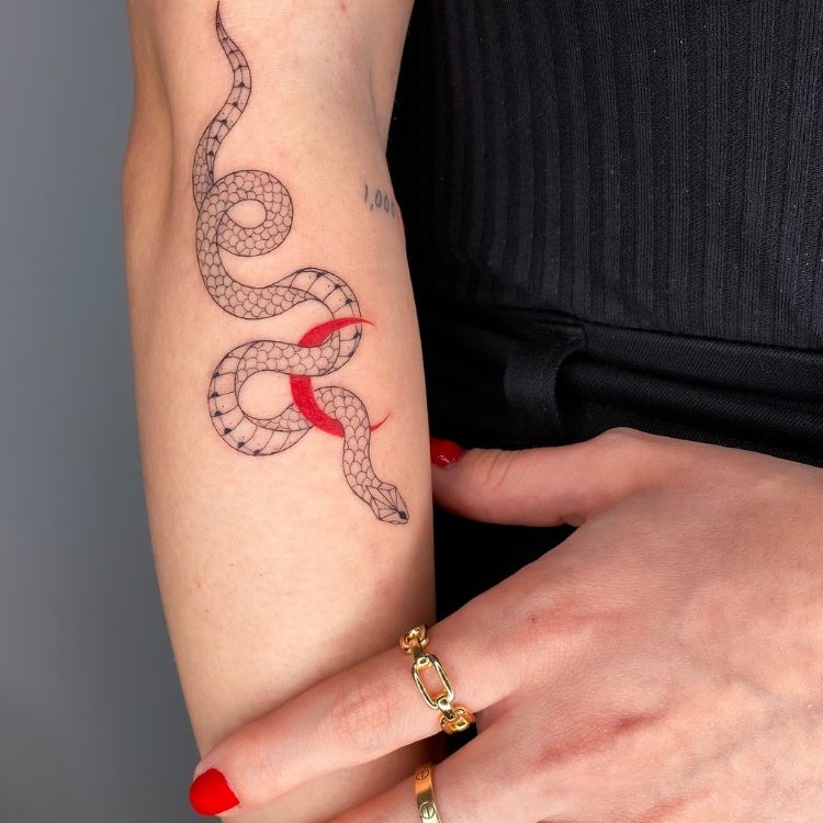 13 uma tatuagem de cobra em preto com uma lua vermelha próximo ao cotovelo, na parte de dentro do braço
