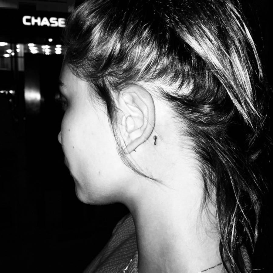 Foto da tatuagem "g" de hailey na parte de trás da orelha esquerda
