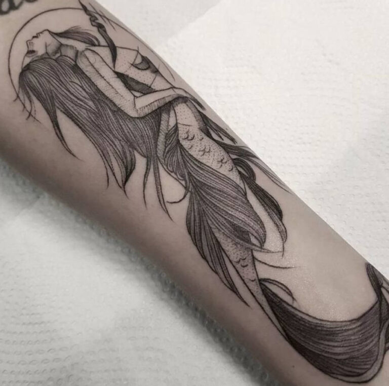Foto de braço tatuado com uma sereia olhando para cima