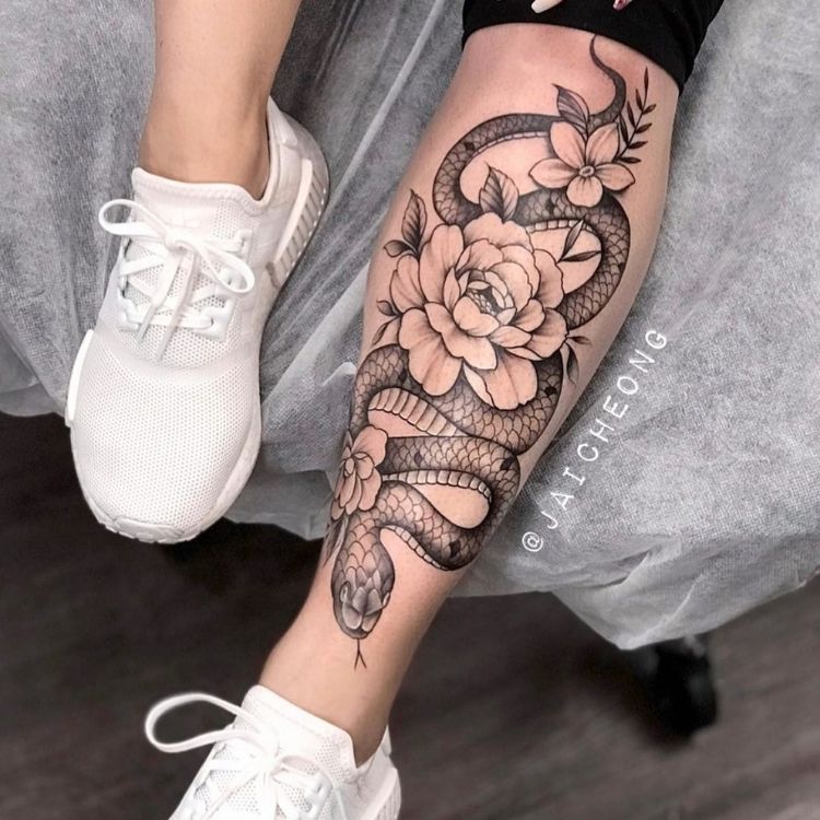 24 uma tatuagem na canela com uma cobra e várias rosas