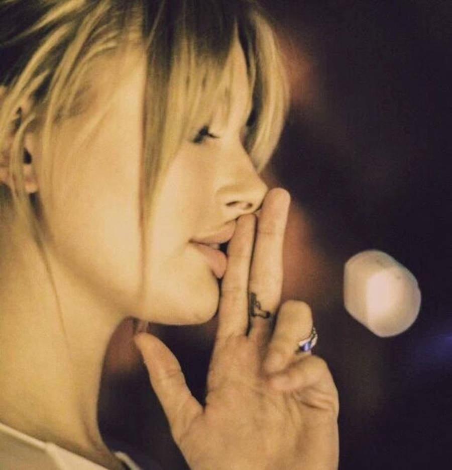Tatuagem Hailey Bieber no dedo médio de arma
