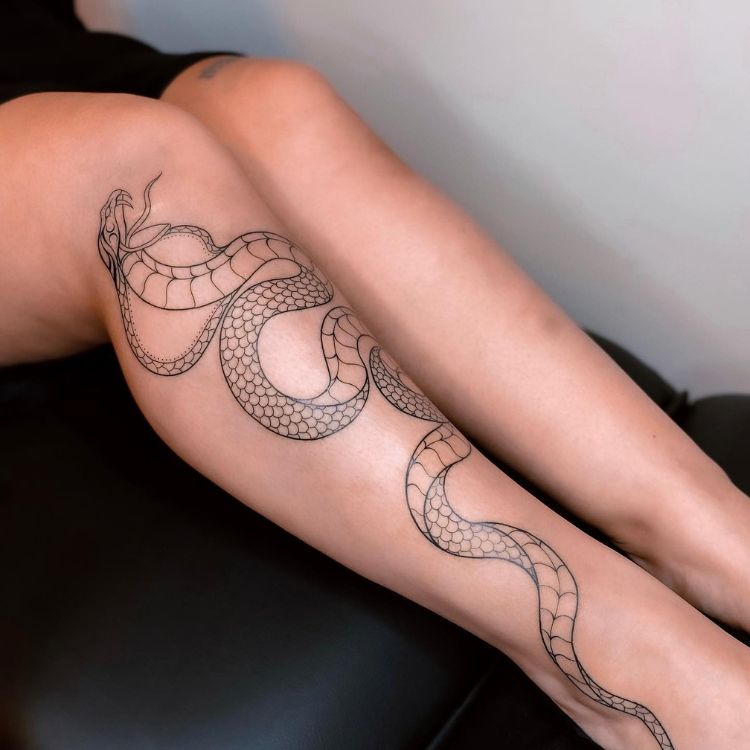 5-2 pernas femininas com uma cobra tatuada em uma delas