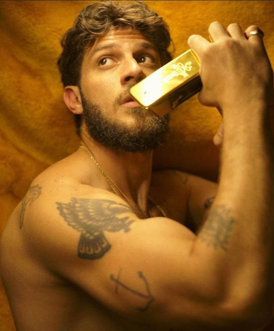 5-tatuagem-chay-suede Foto de Chay Suede com vidro de perfume na boca e foco na tatuagem de âncora