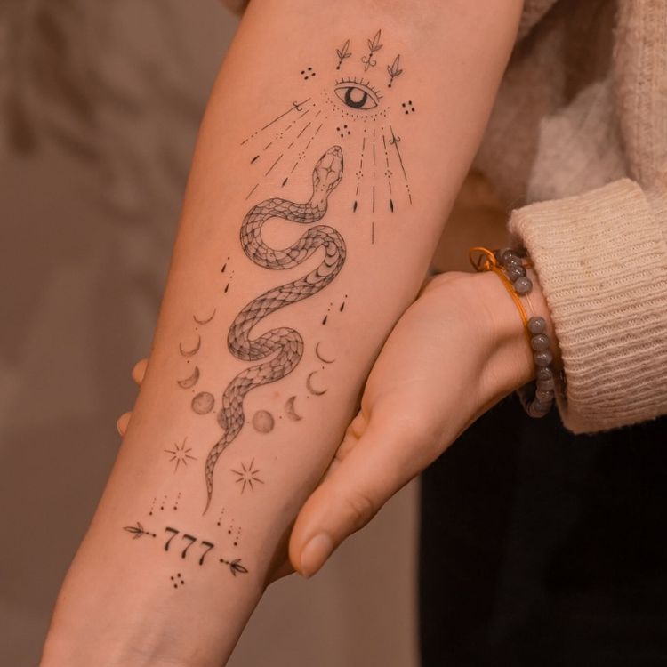 8-2 tatuagem de cobra com as fases da lua ao redor, um olho no topo e os números 777 em baixo