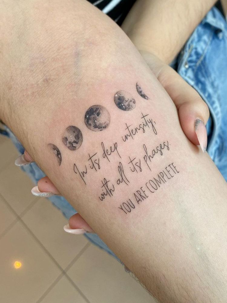 imagem-11-1 Foto de tatuagem das fases da lua, com frase em inglês embaixo.