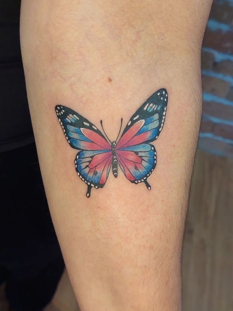 imagem-4-1 Foto de tatuagem colorida de borboleta no antebraço.