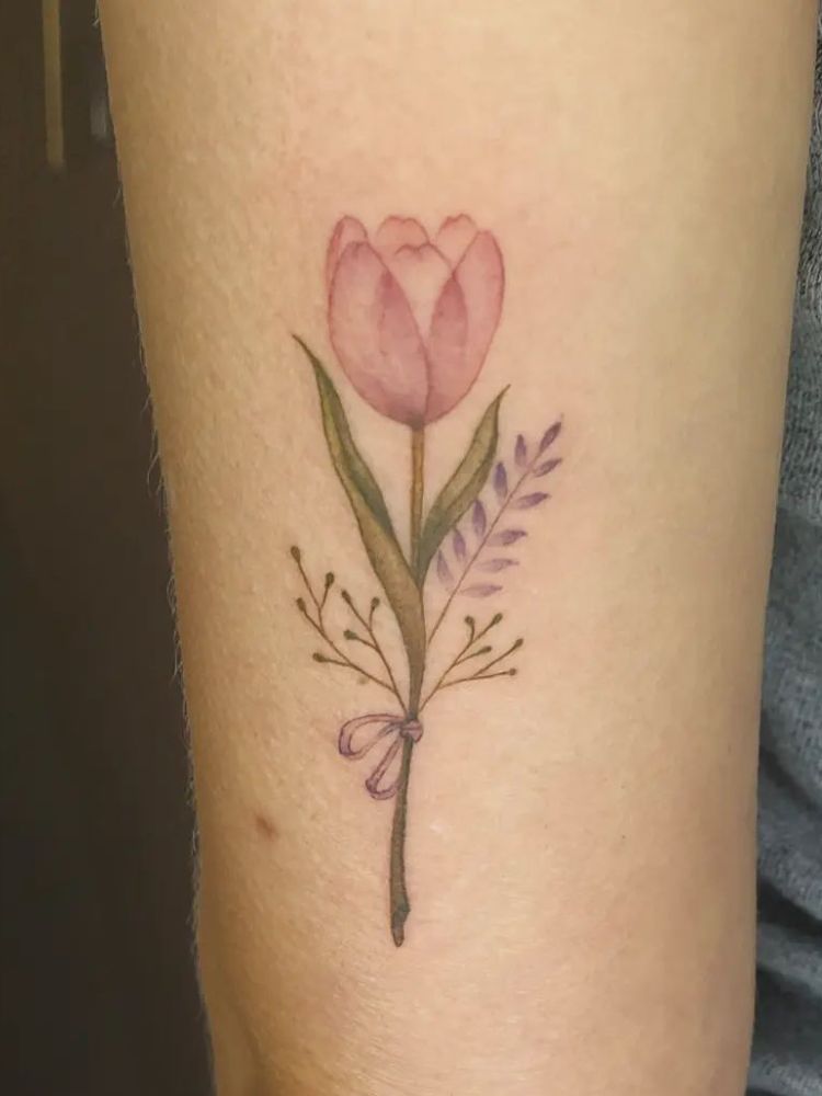 imagem-48 Foto de tatuagem no braço, com tulipa rosa e um ramo roxo.