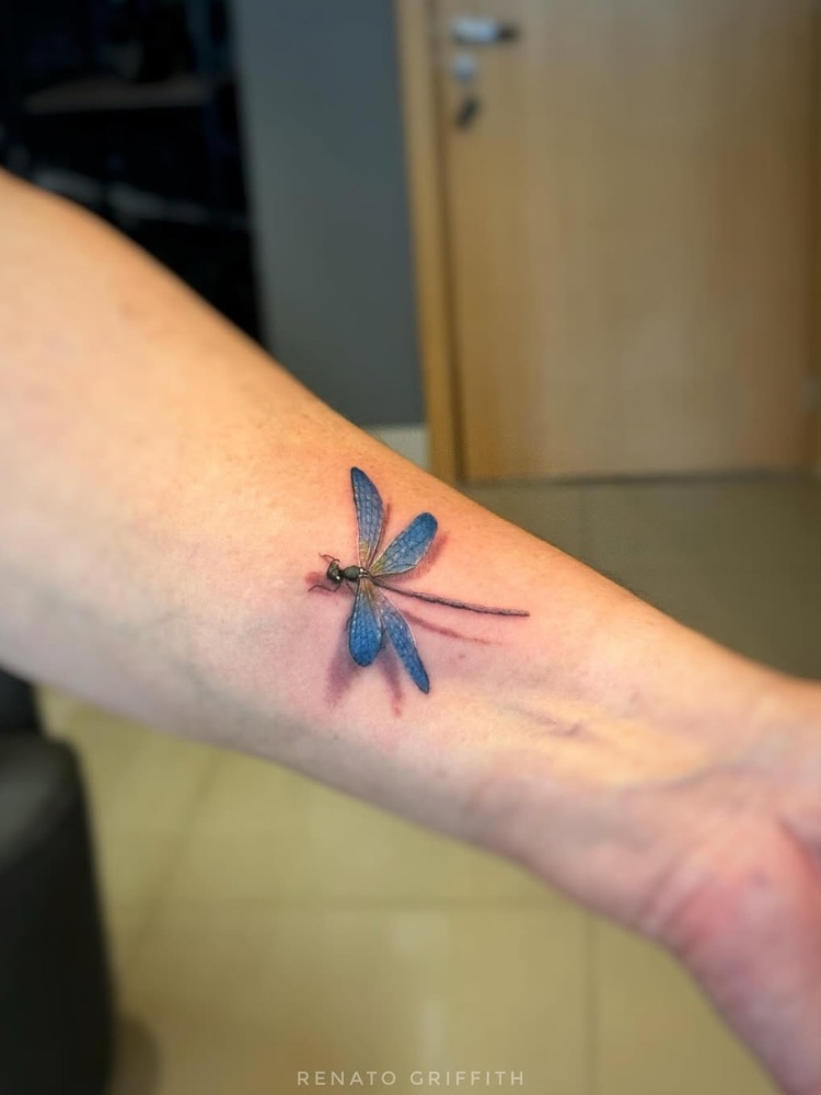Braço com tattoo 3D de libélula azul