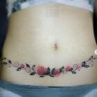 tatuagem delicada de ramo de flores cobre cicatriz barriga 140x140 1
