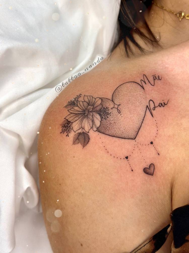 tatuagem-feminina-ombro-coracao-mae-pai Pessoa de pele clara com ombro tatuado com coração sombreado, flores e escritos "mãe" e "pai"