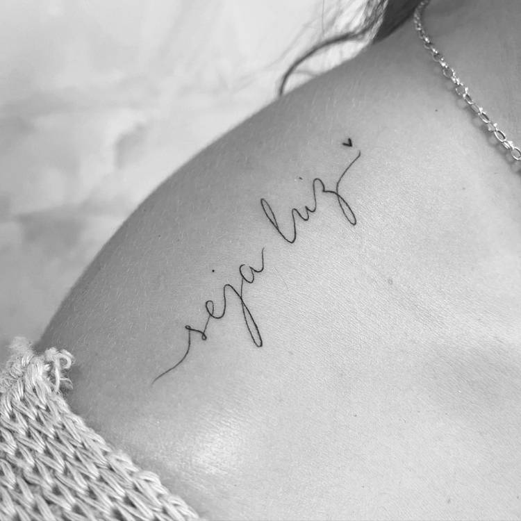 tatuagem-feminina-ombro-frase-seja-luz Foto em preto e branco de uma mulher de pele clara com a frase "seja luz" no ombro