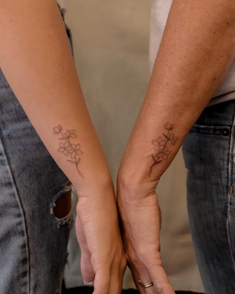 tatuagem-mae-e-filho-flor-2 Tatuagem delicada de ramo de flor em braço, próximo do pulso, em dois braços